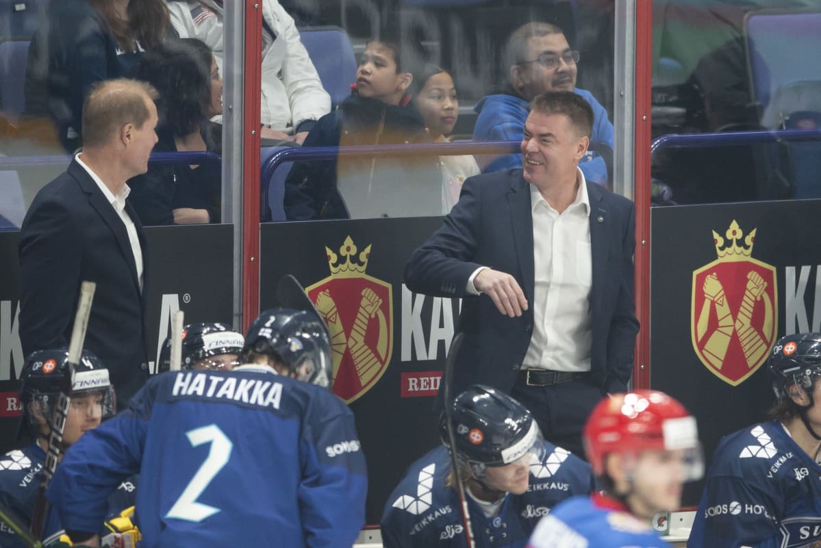 Raimo Helminen hymyilee vaihtoaition penkin takana.