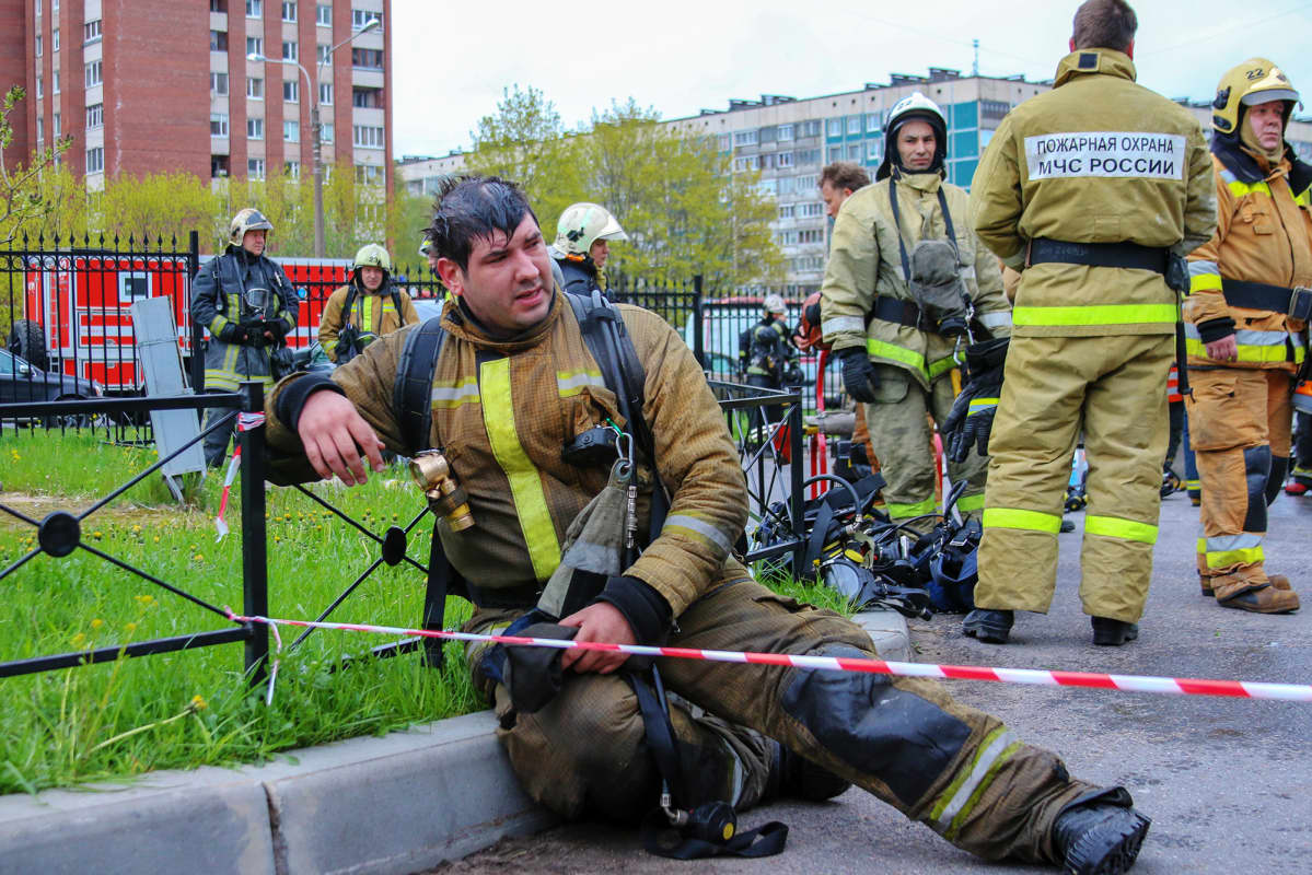 Kuvassa väsynyt palomies lepää maassa.
