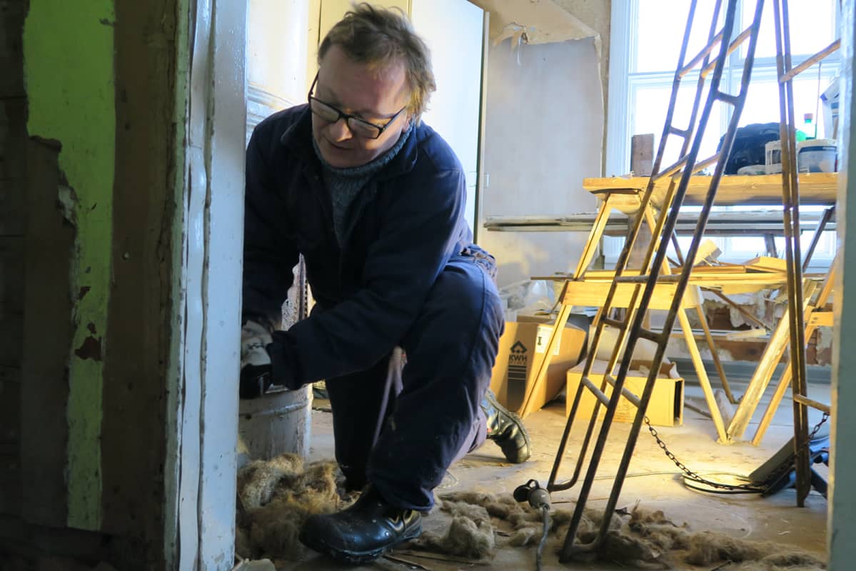 Metallimies Marko Hurmerinta purkaa oven kiinnityksiä