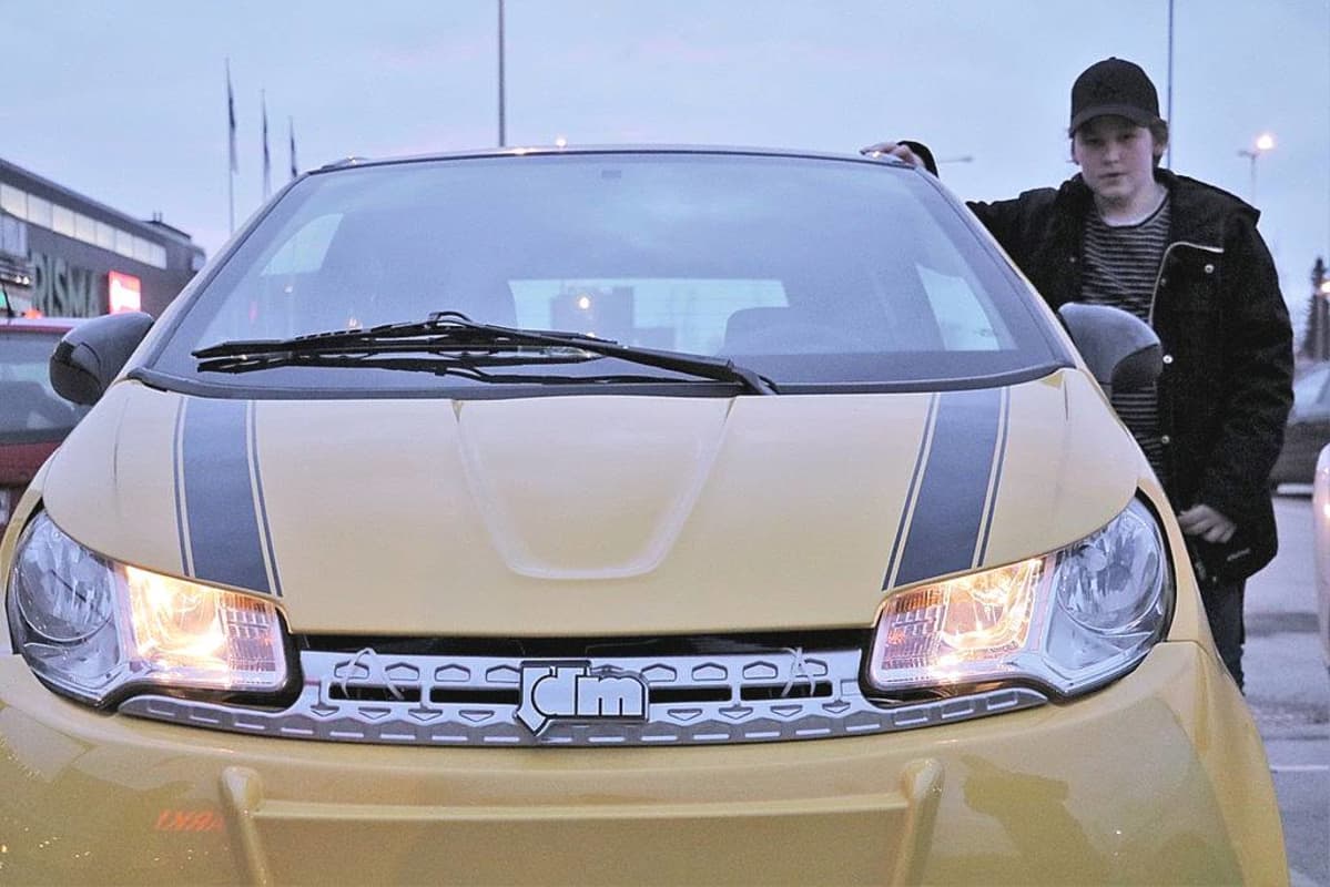 Konsta Oulusta mopoautonsa vierellä.