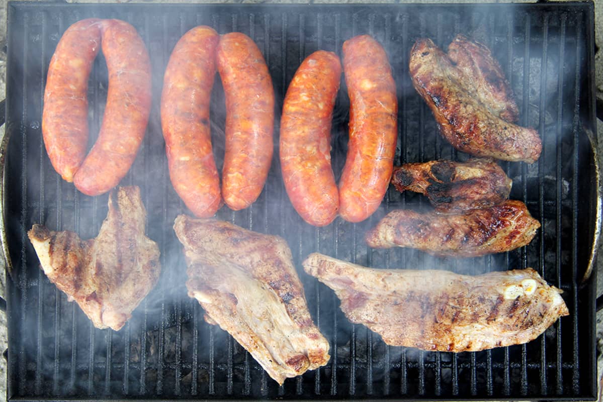 Grillissä kypsyy ribsejä ja erikoismakkaroita.