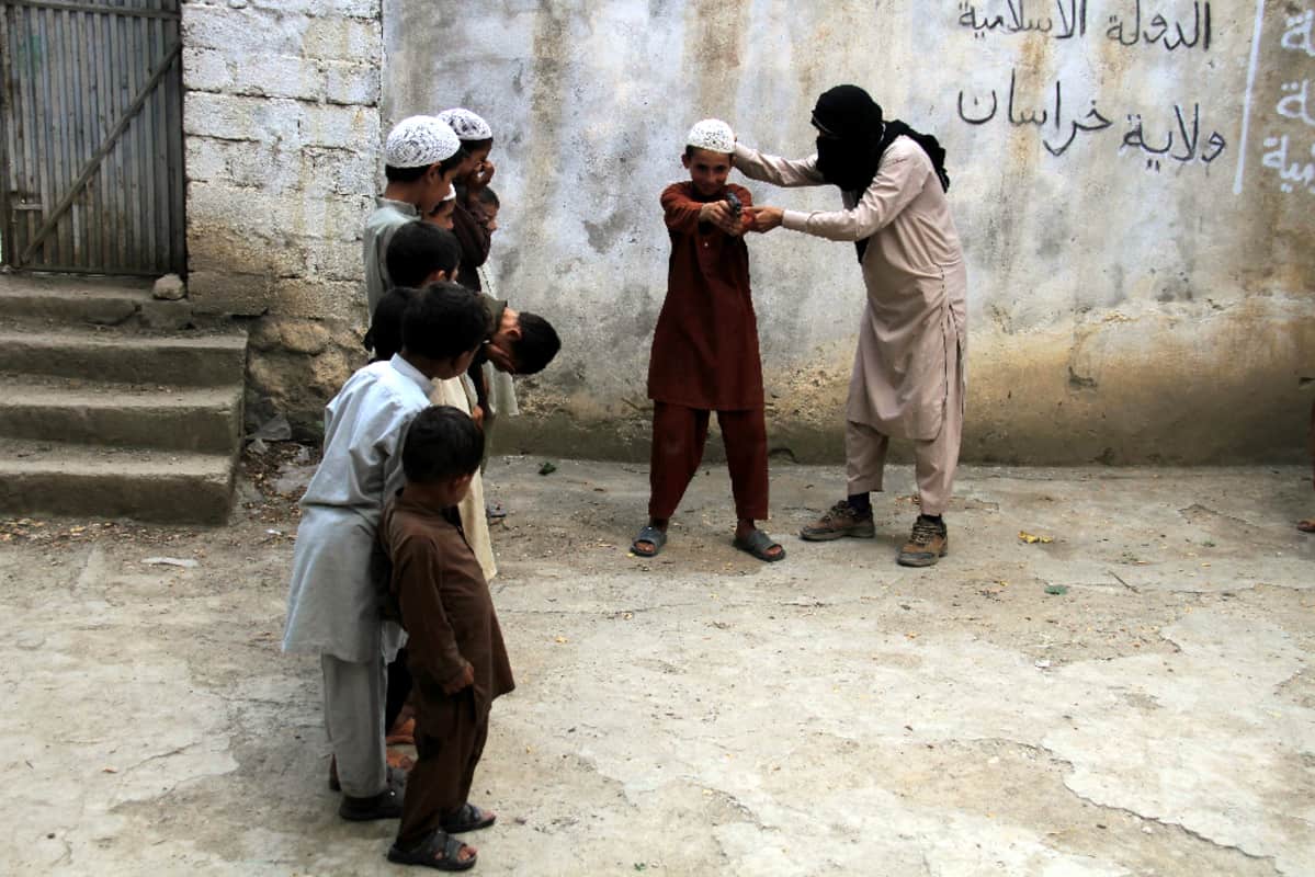 Isis-sotilas opettaa lapsia aseenkäytössä Kunarin provinssissa Afganistanissa 30. heinäkuuta 2015.