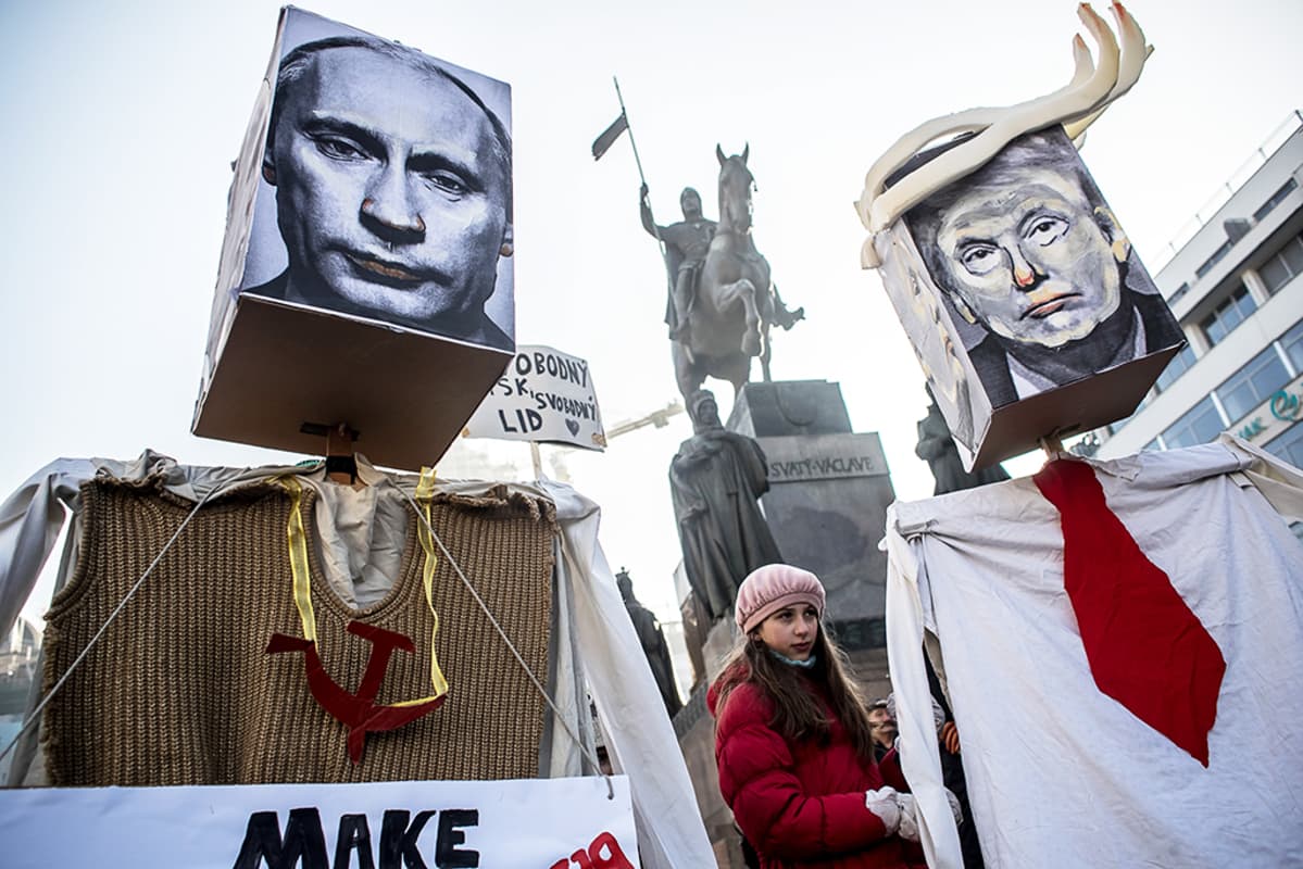 Mielenosoittajat kantavat Donald Tumpin ja Venäjän presidentin Vladimir Putinin kuvia Prahassa.