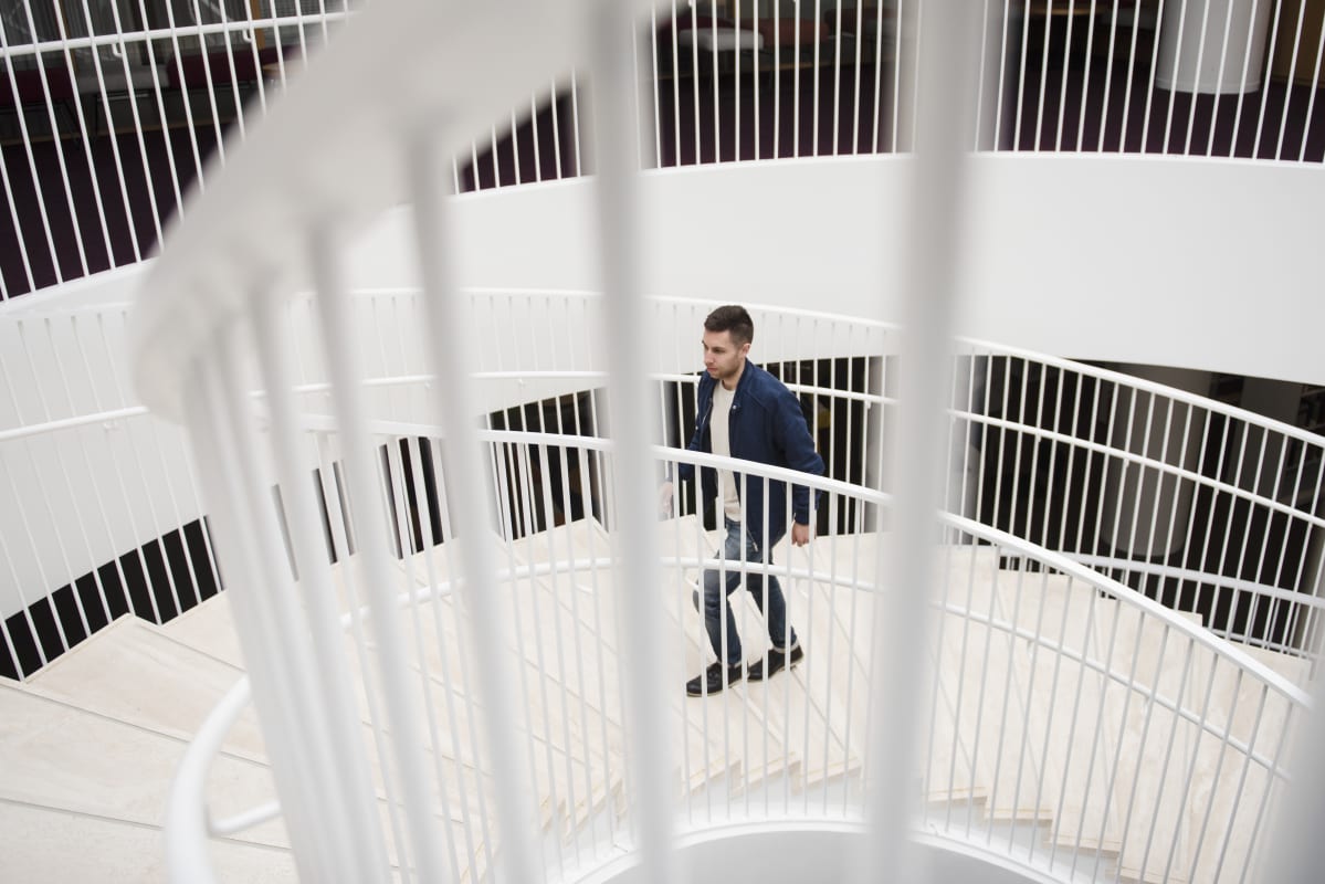 Aleksi Neuvonen kävelee Kaisa -kirjaston rappusia ylös.