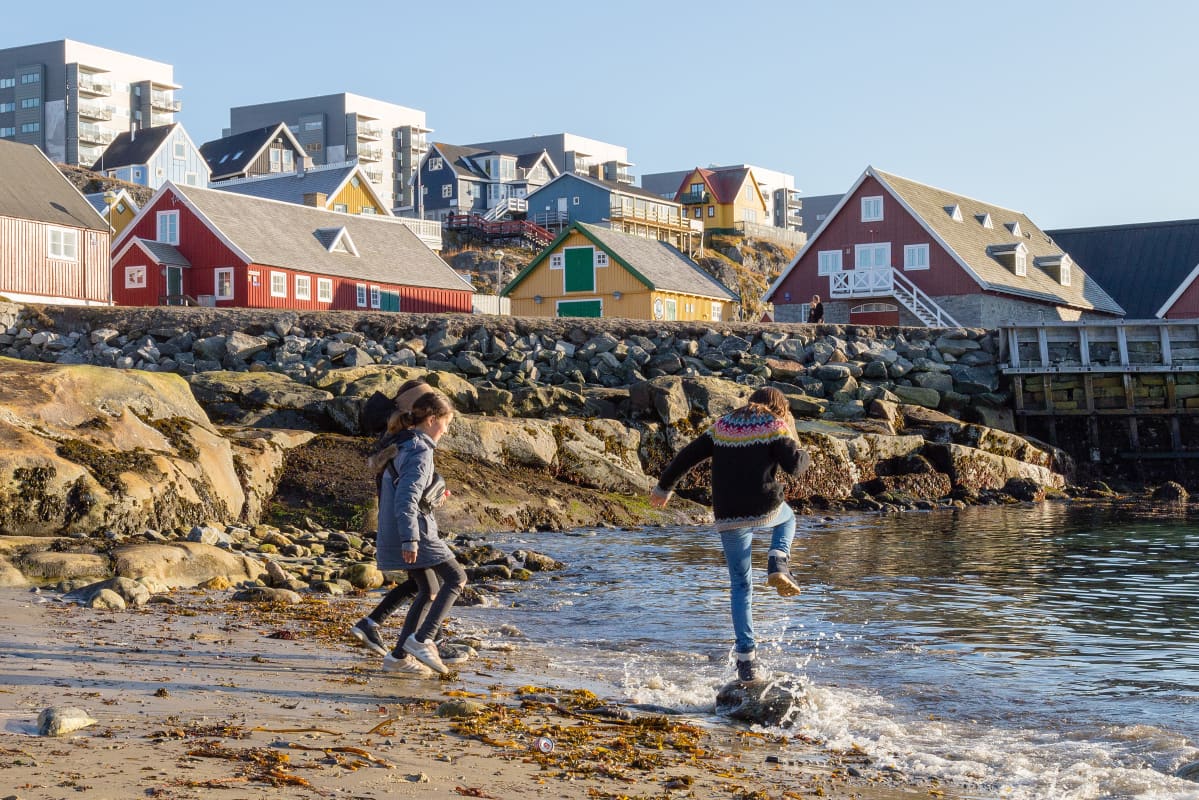 Lapset leikkivät rannalla Grönlannin Nuukissa