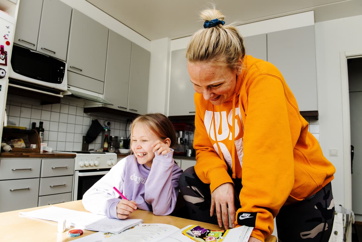 Miira ja Alina nauravat keittiön pöydän ääressä.