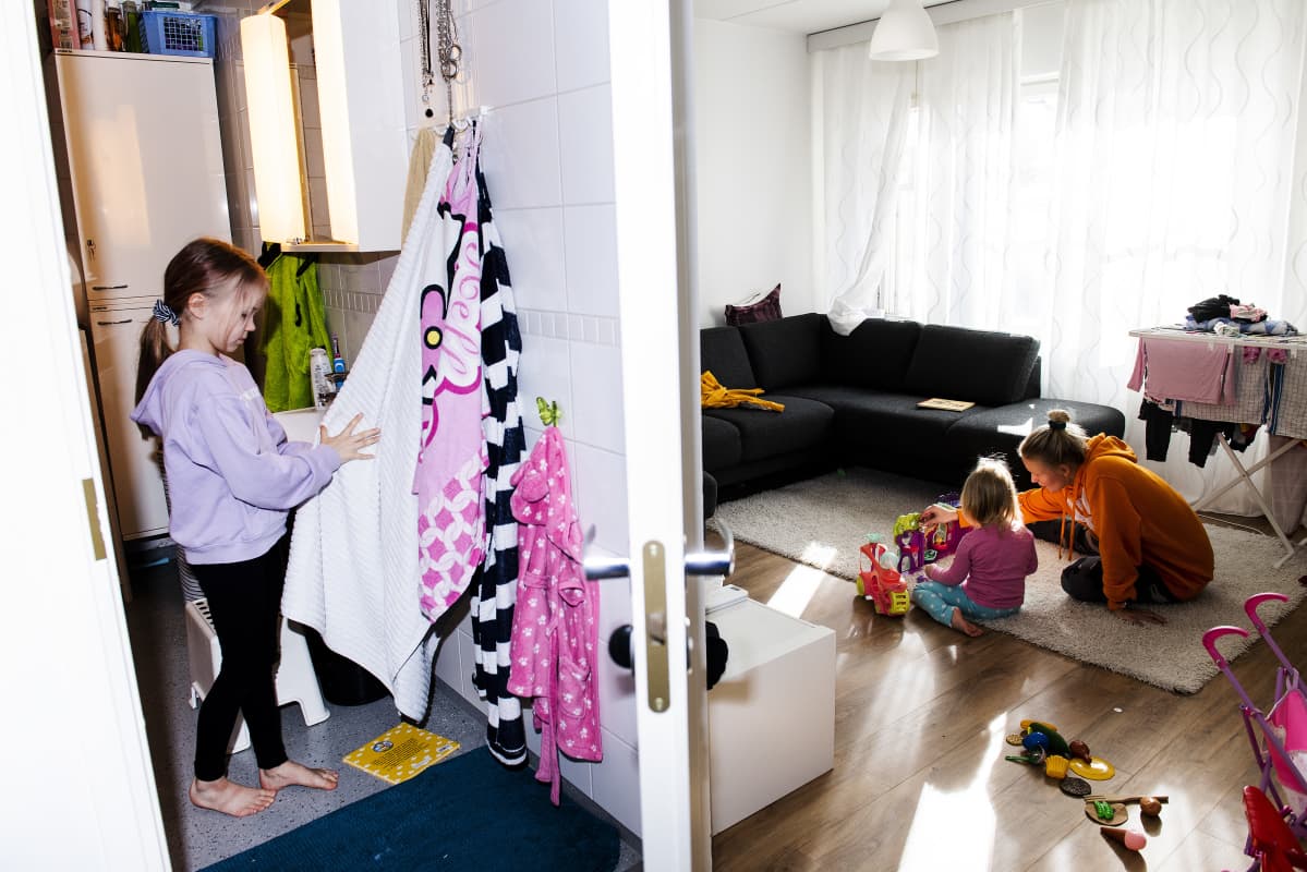 Alina kuivaa kätensä vessassa, Miira ja Sofia leikkivät olohuoneessa.