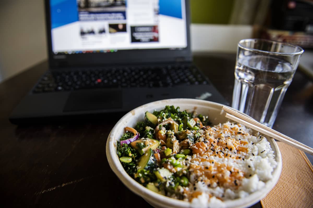 Kuvassa on poke bowl -ruoka-annos lohella ja riisillä keittiön pöydällä.