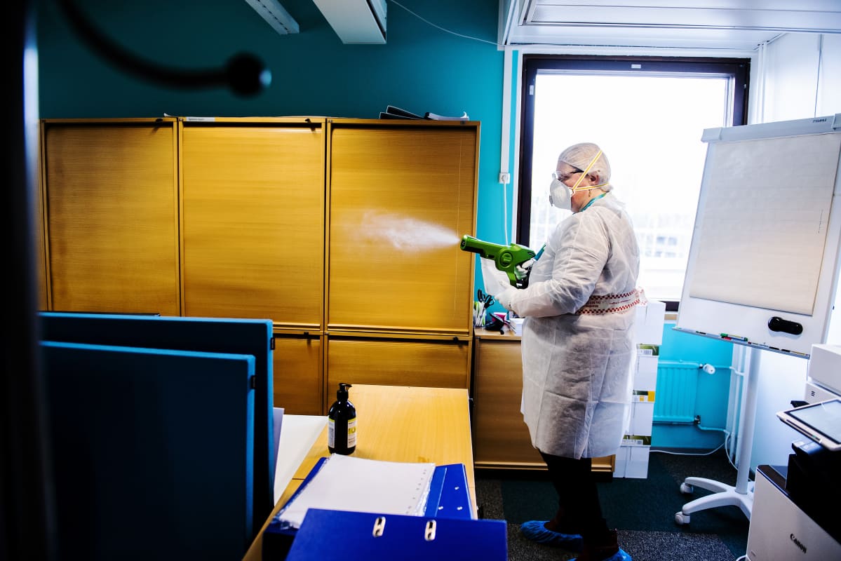 Kuvassa palvelucontroller Päivi Suojasalo puhdistaa kolmannen kerroksen toimistotiloja.
