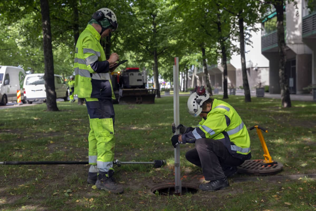 Viemärin syvyyttä mitataan.