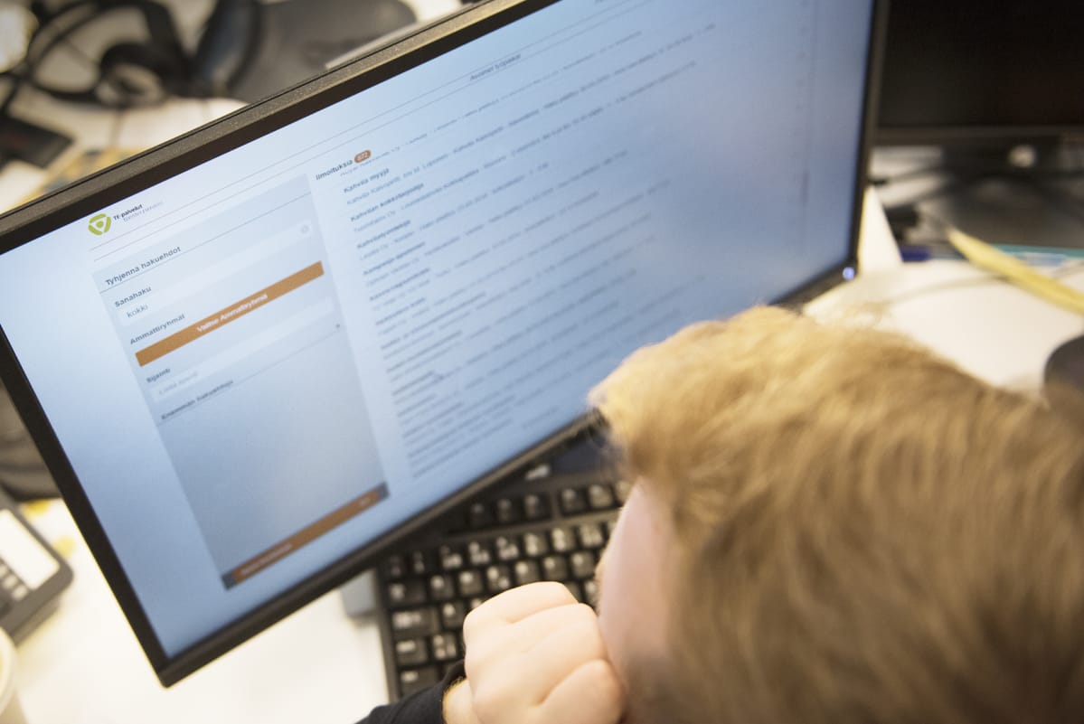 Mies katsoo tietokoneelta vapaita työpaikkoja työvoimatoimiston sivuilta.
