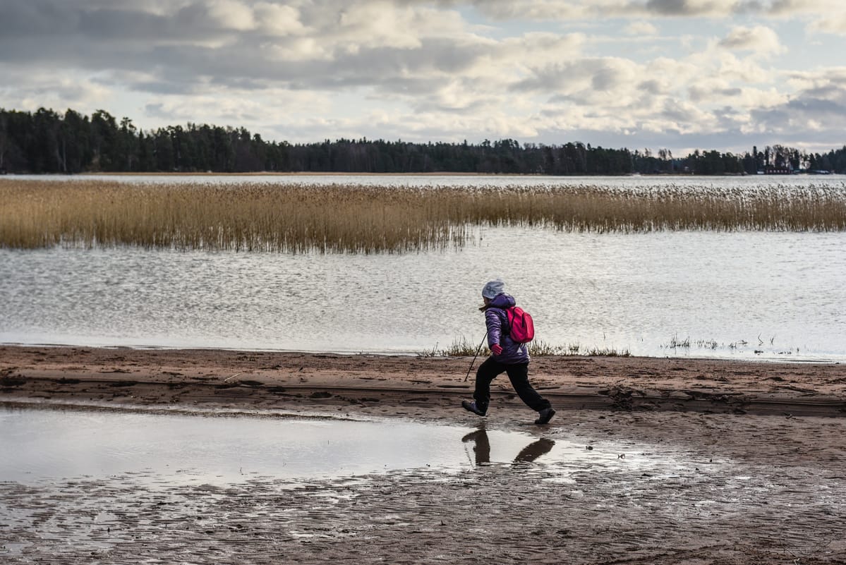 Lapsi juoksee rannalla.