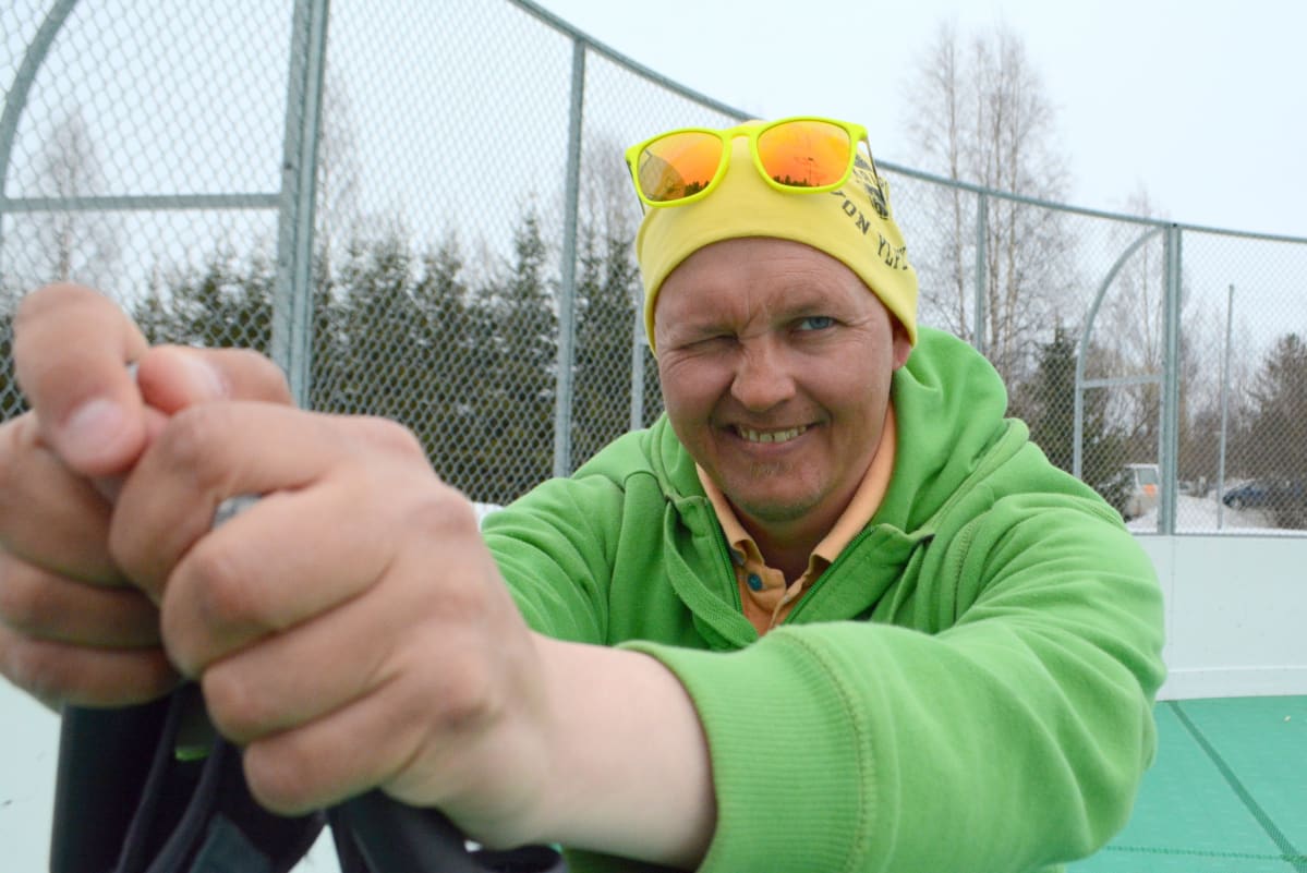 Pasi Raatikainen nojaa hiihtosauvoihin ja iskee silmää