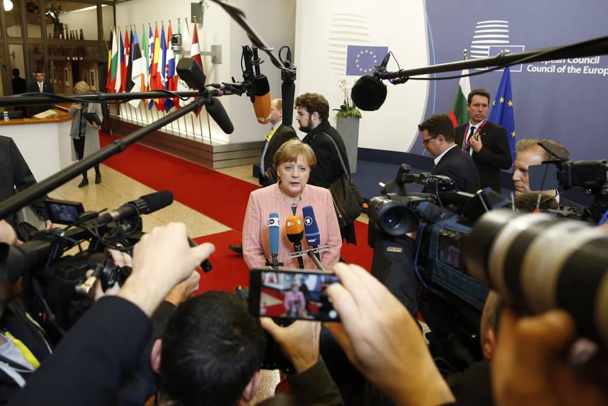 Saksan Angela Merkel kameroiden ympäröimänä.
