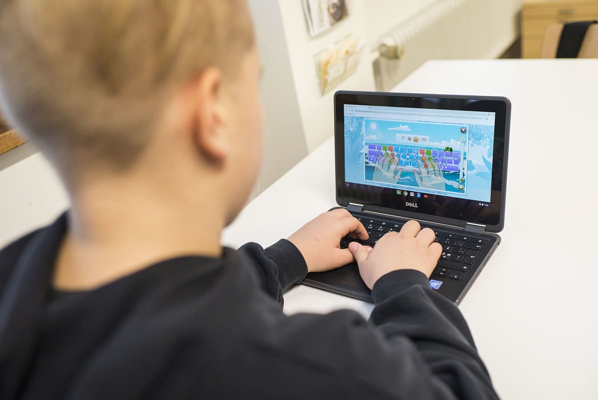 Poika käyttää Chromebookia.