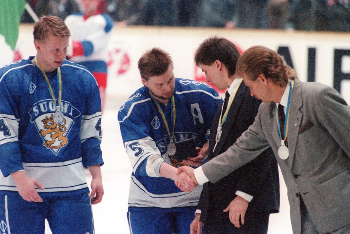 Leijonien kapteeni Timo Jutila ja päävalmentaja Pentti Matikainen kättelevät hopeamitalit kaulassa.