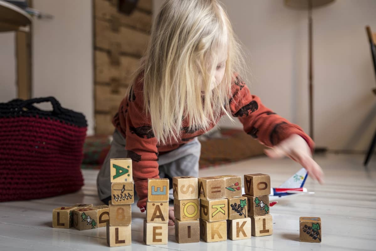lapsi leikkii kirjainpalikoilla