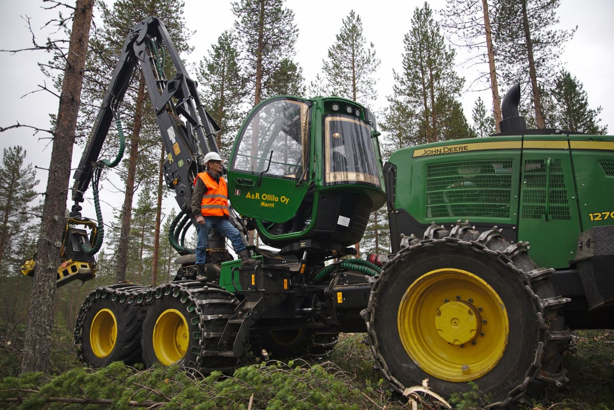 Heikki Nivala seisoo metsäkoneen päällä.
