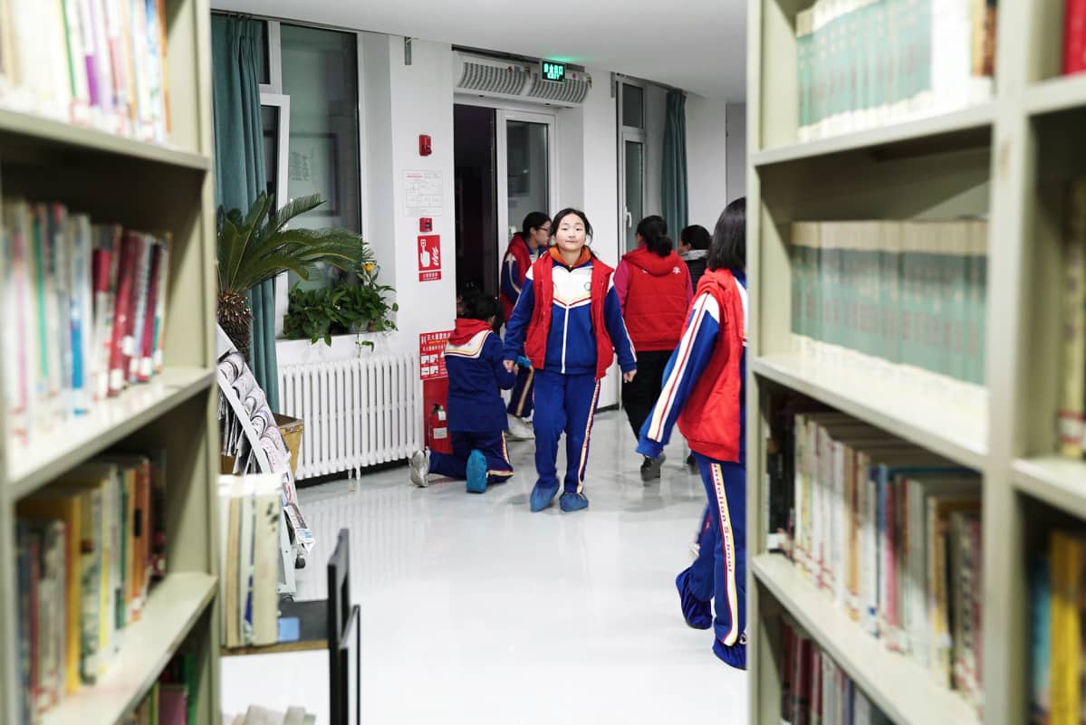Monet koulun oppilaiden vanhemmista asuvat Pekingin laidalla muutaman neliön huoneissa,