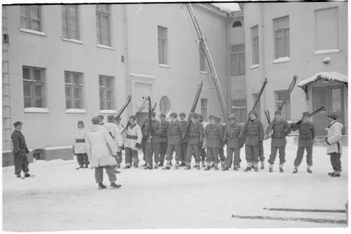 Sotilaita talon pihalla.