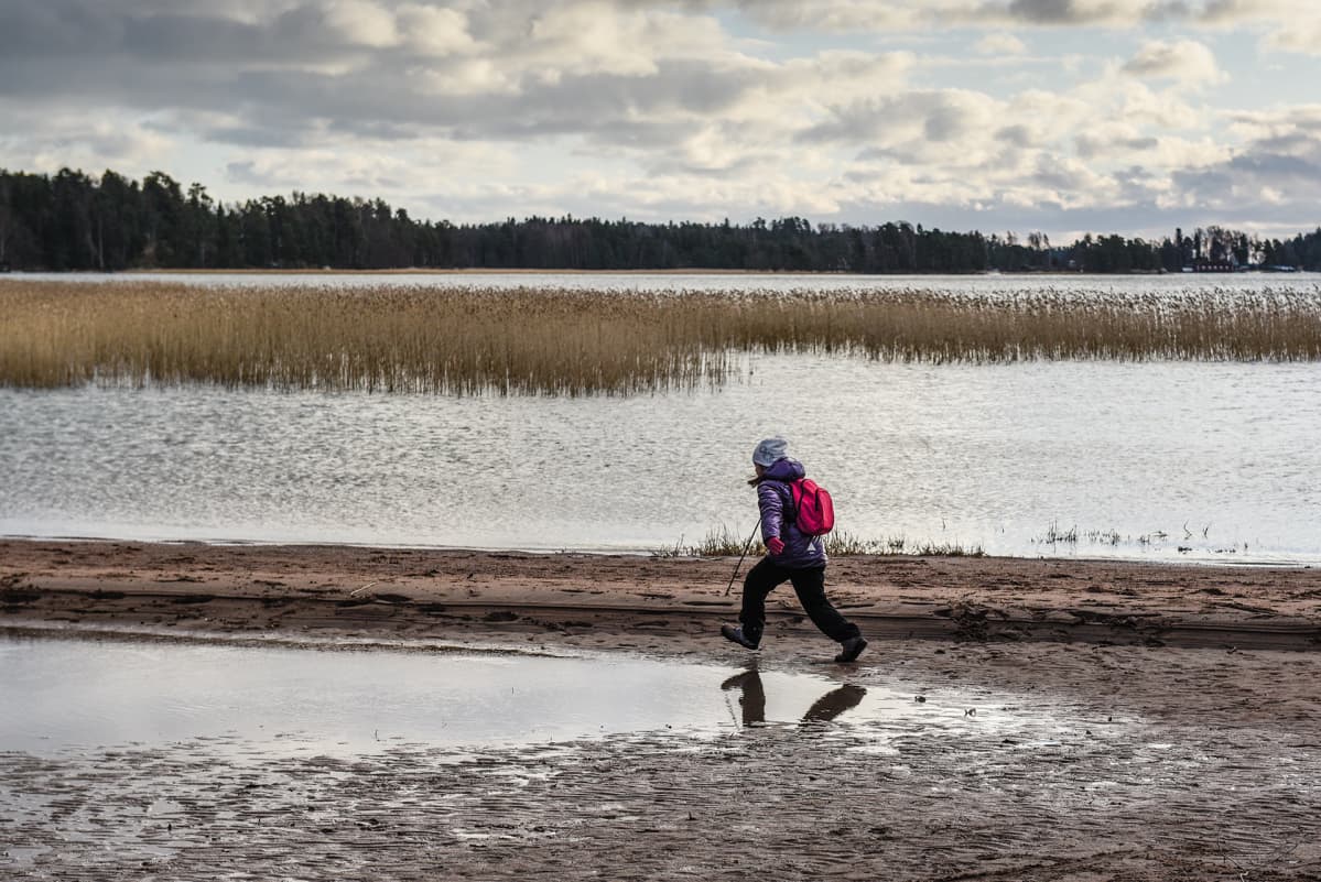 Lapsi juoksee rannalla.
