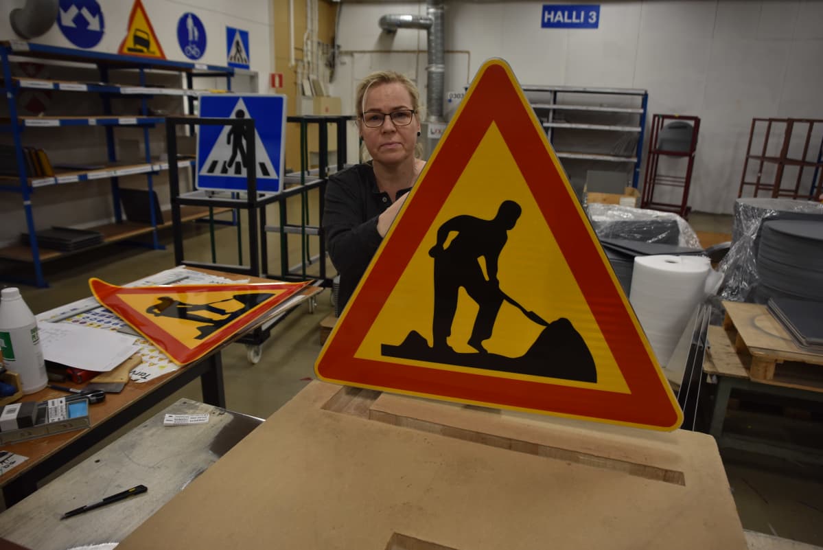 Kaisa Kivekäs ja vanhanmallinen tietyömaan merkki.