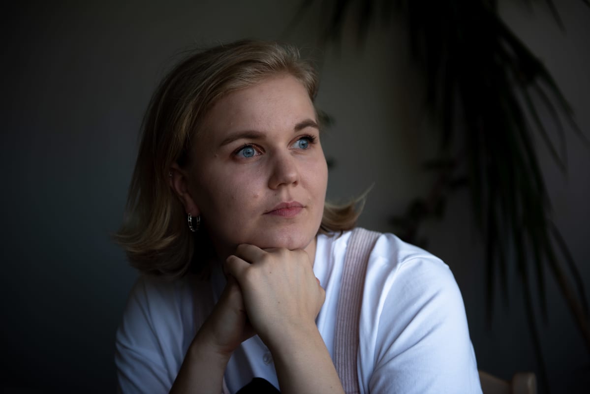 Venla Salomaa katsoo kotonaan ikkunasta ulos työskennellessään.