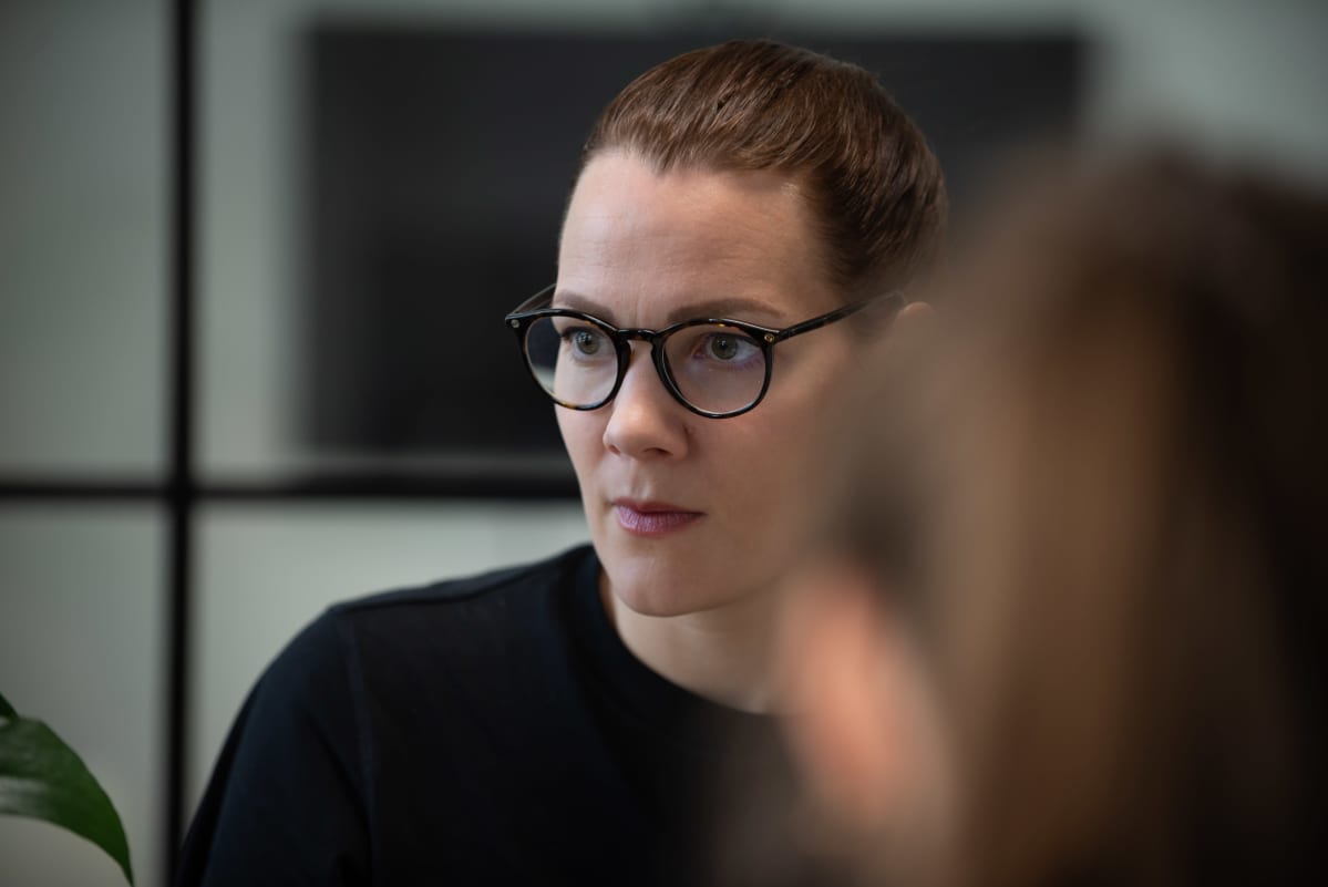 Outi Ellilä istuu pöydän ääressä kokouksessa.