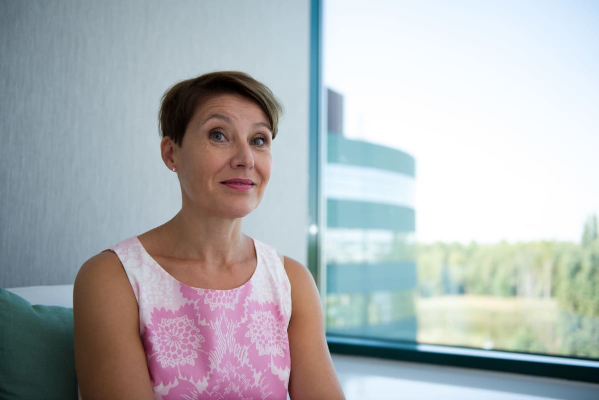 Nina Kalajoki istuu ikkunan ääressä toimistossa.