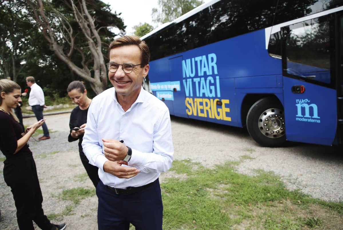 Kristersson hymyilee bussin edessä