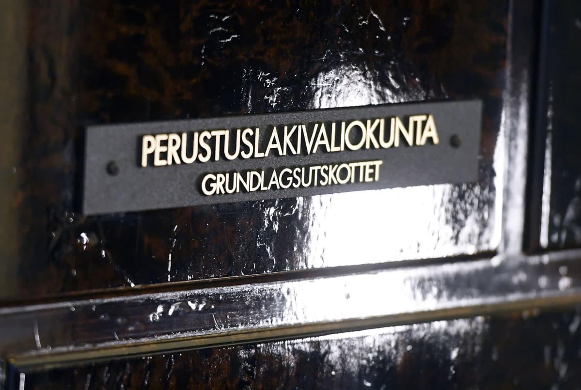 Perustuslakivaliokunnan kilpi ovessa.