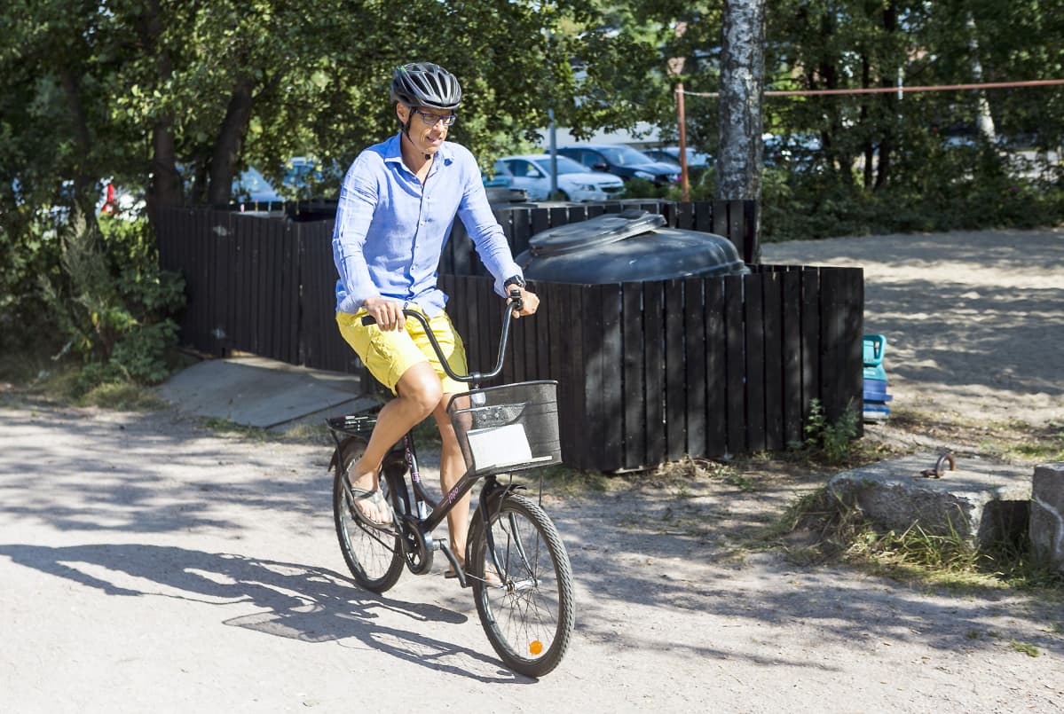 Alexsander Stubb saapuu tiedotustilaisuuteensa polkupyörällä.