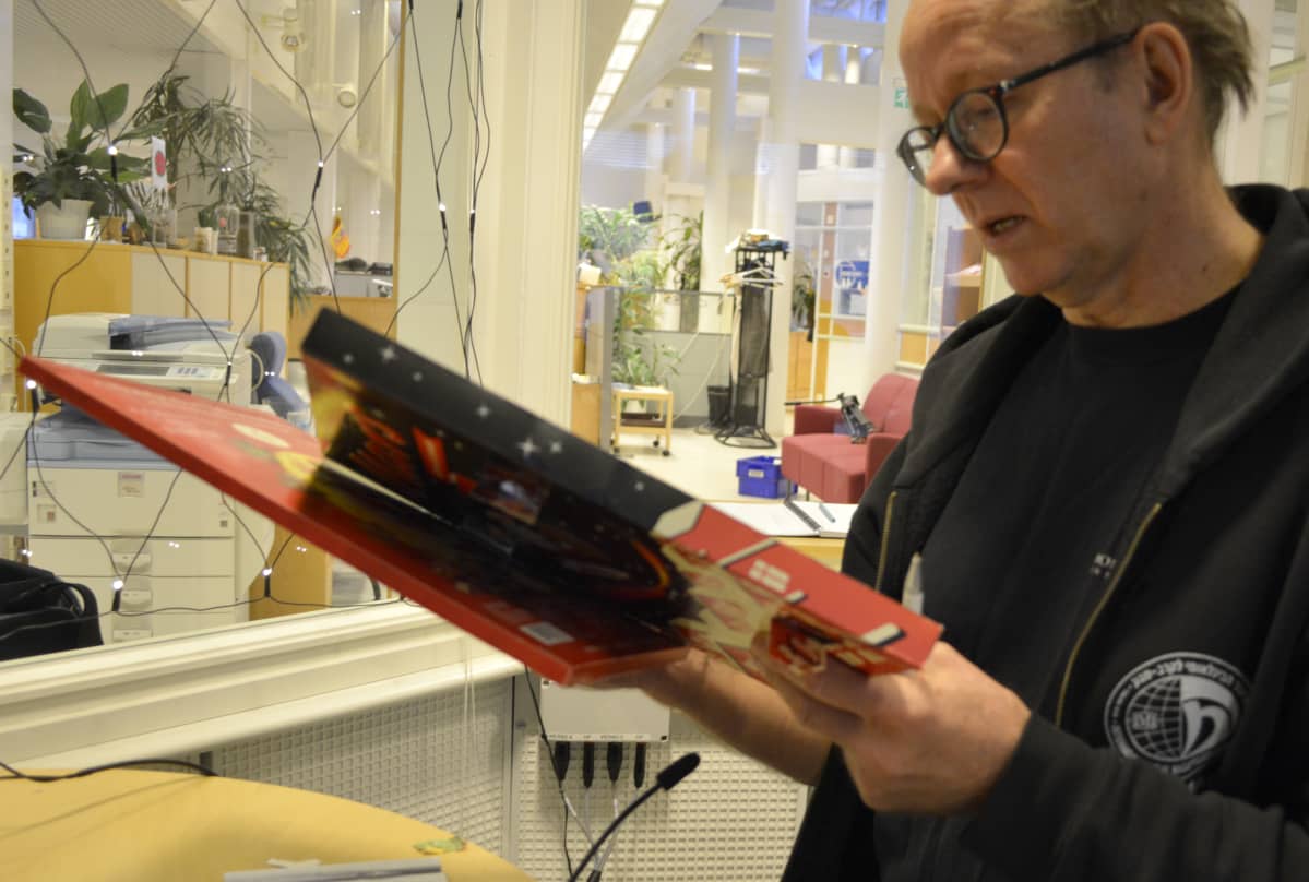 Tapani Ripatti lukee joulukalenterin tuoteselostetta.