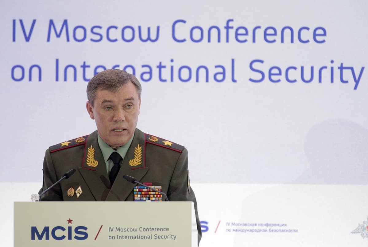 Kenraali Gerasimov seisoo puhujankorokkeen takana Moskovassa kansainvälisen turvallisuuden konferenssissa. Hänellä on yllään vihreä univormu, rintamuksessaan rivi kunniamerkkejä ja lehväkuviot kauluksissa.