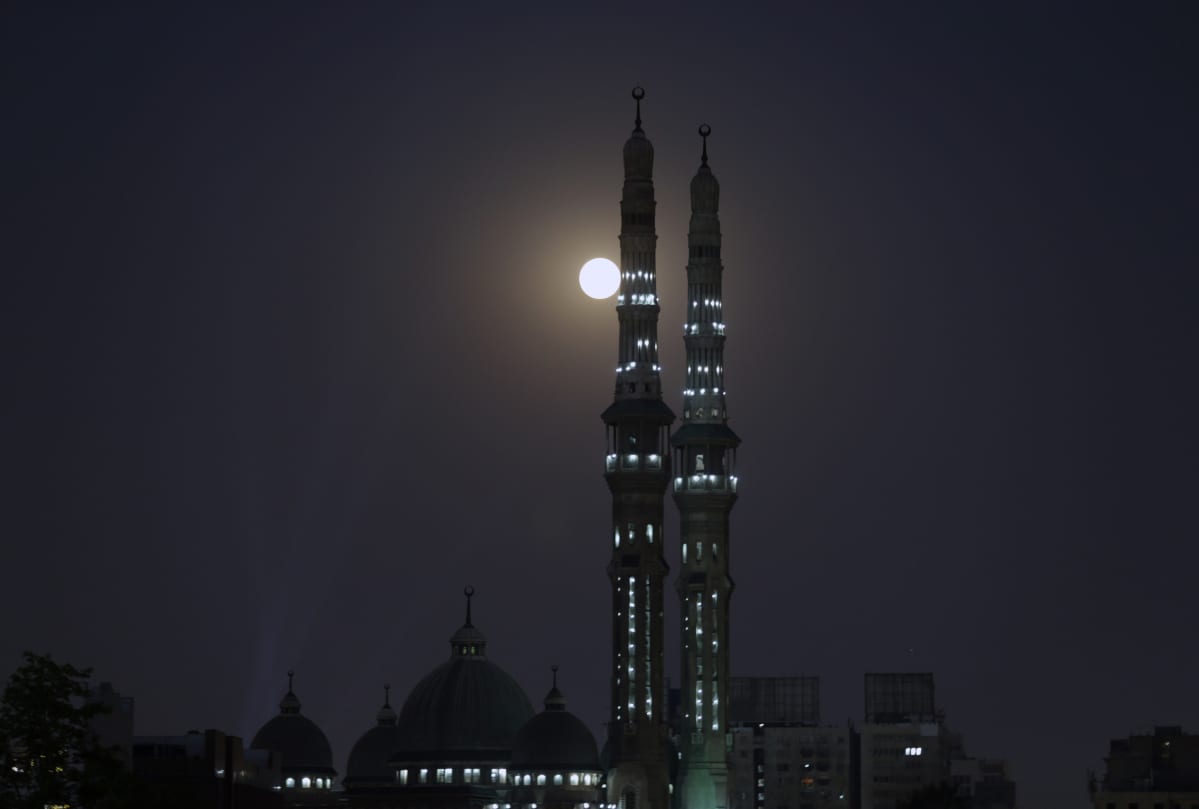 Kuu näkyy moskeijan tornien vieressä Kairossa Egyptissä.