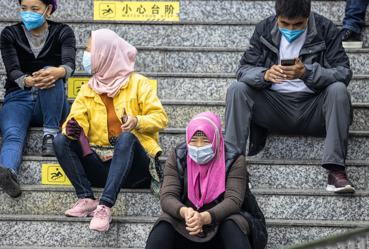 Uiguureja hengitysmaskit päällään Guangzhoun päärautatieaseman lähellä 12. helmikuuta 2020.
