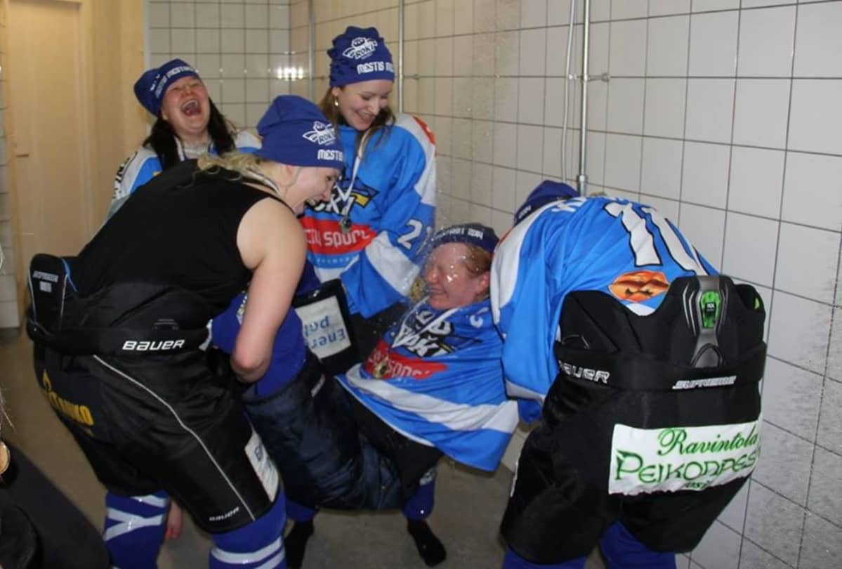 RoKin naisten jääkiekkojoukkue juhlii Mestis-mestaruutta. Kapteeni Oona Parviainen on kannettu suihkuun.