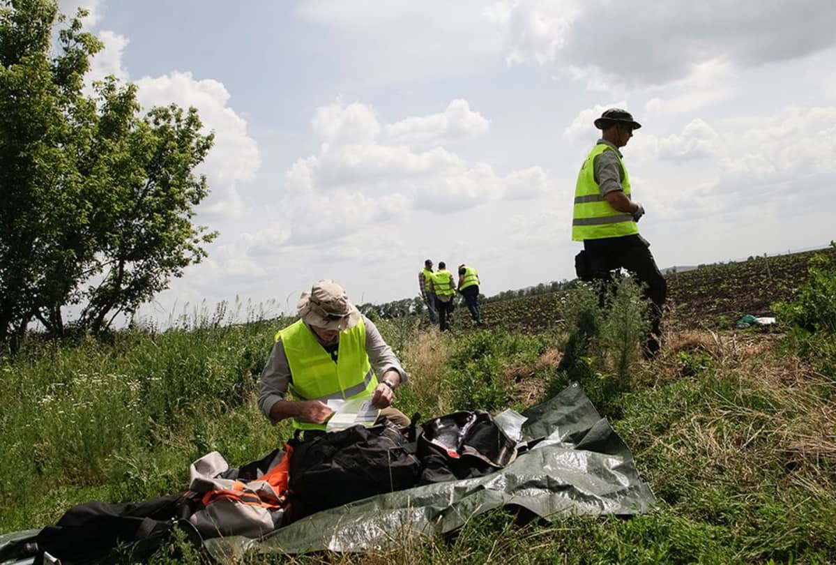 Tutkijoita MH17 lennon putoamispaikalla 19.kesäkuuta lähellä Donetskia.