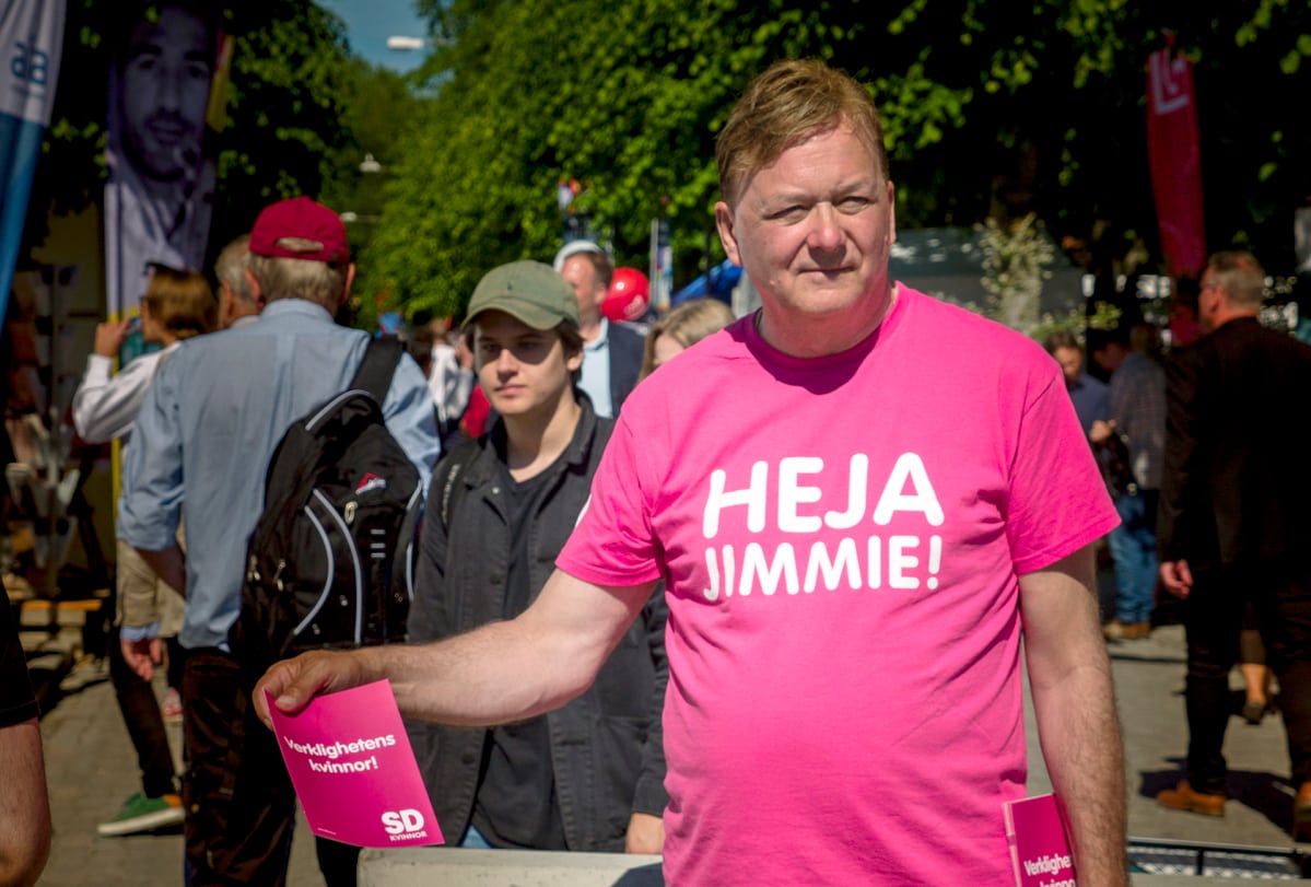 Miehellä on päällään pinkki Heja Jimmie! -paita.