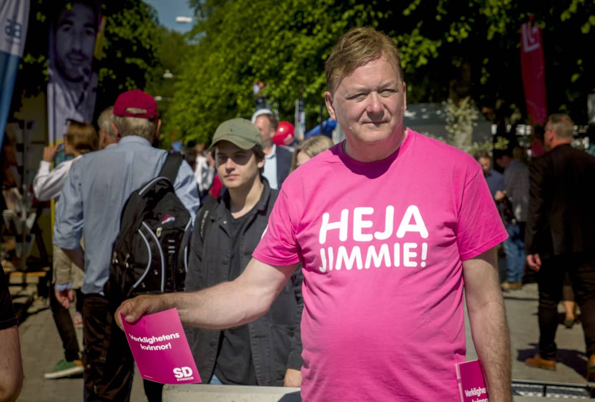 Miehellä on päällään pinkki Heja Jimmie! -paita.