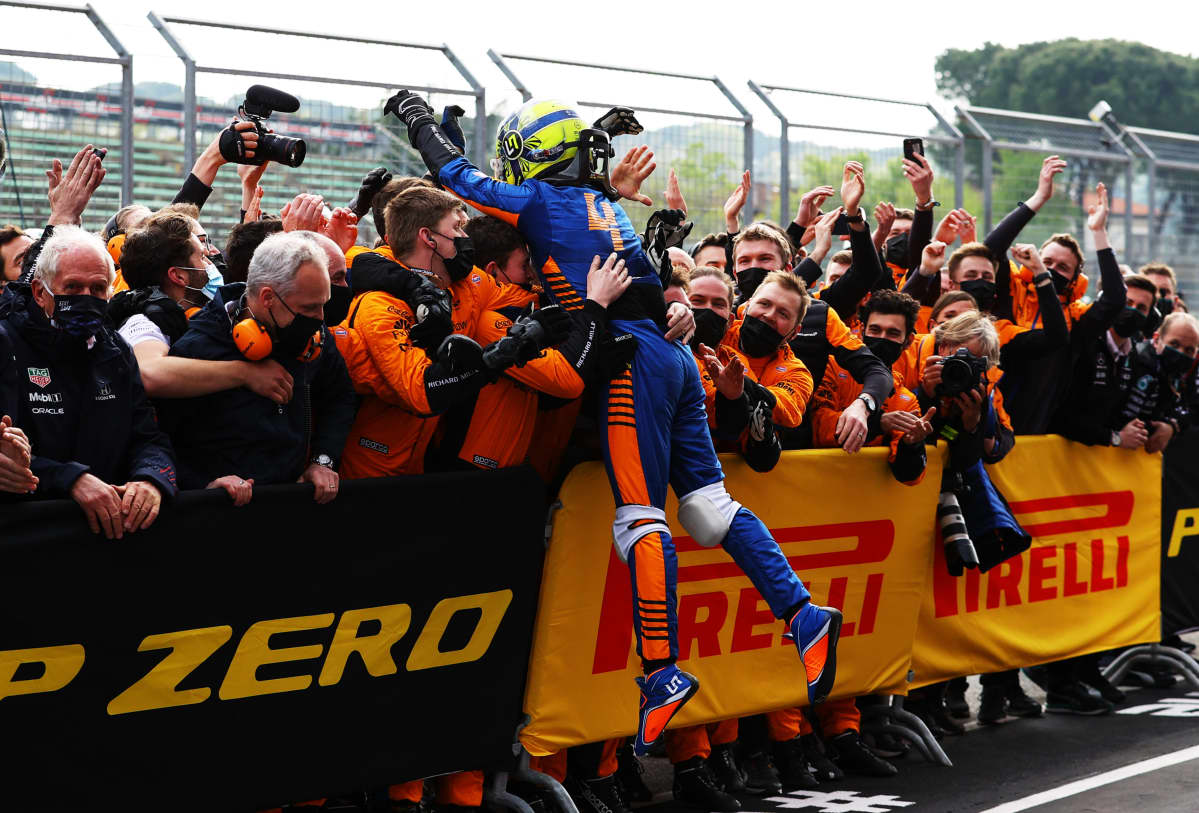Lando Norris hyppää juhlivia McLarenin mekaanikkojen joukkoon Imolan kolmossijan ratkettua.