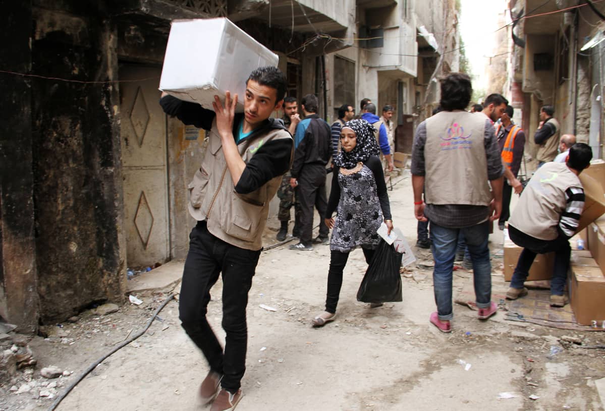 UNRWA.n avustustyöntekijät jakavat avustuspaketteja.