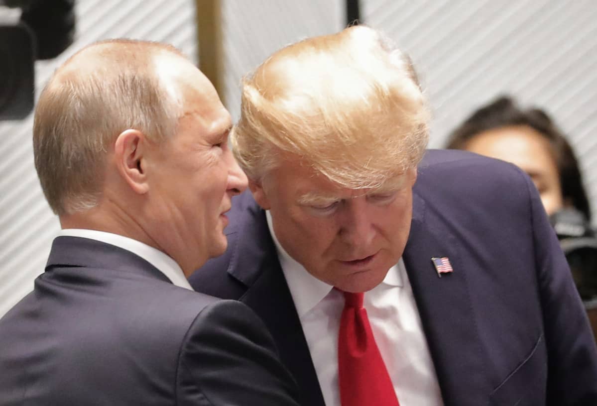 Presidentti Vladimir Putin kuiskaa presidentti Donald Trumpin korvaan marraskuussa 2017.