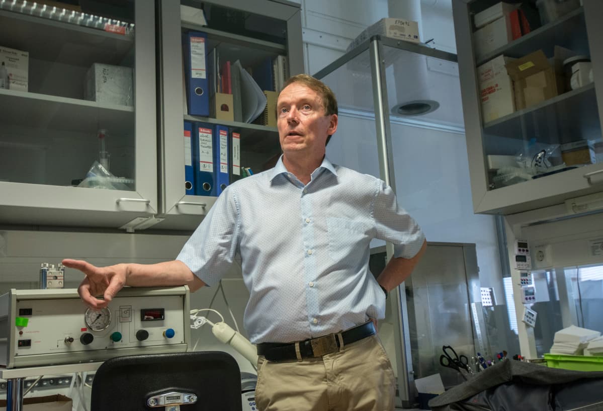 Professori puhuu toimittajalle laboratoriossa.