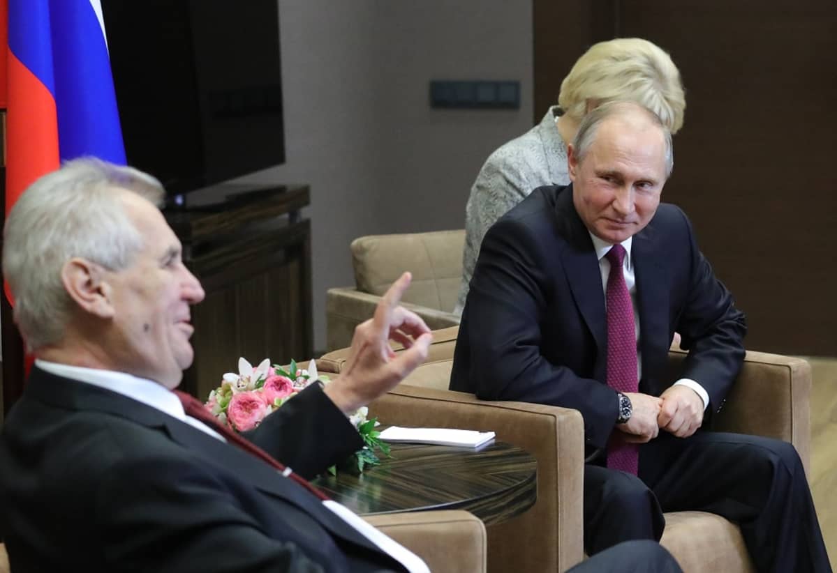 Zeman ja Putin istuvat nojatuoleissa, Zeman puhuu, Putin hymyilee. Taustalla näkyy Venäjän lippu ja Putinin takana istuu nainen, mahdollisesti tulkki.