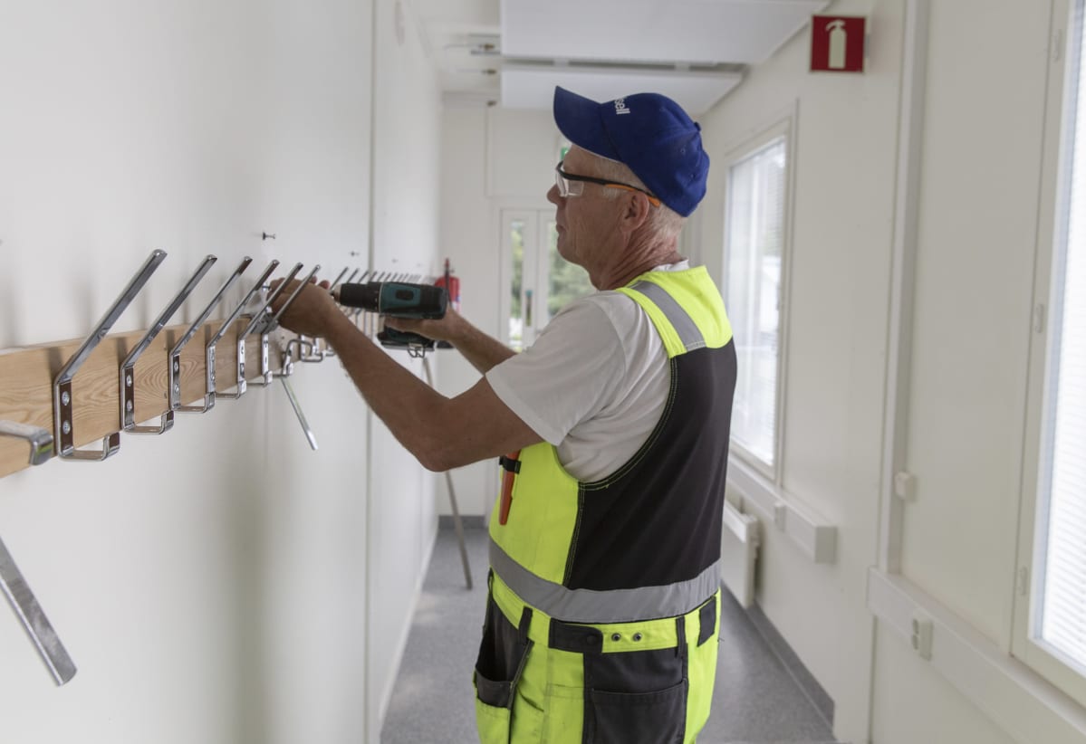 Veli-Matti Sihvola asentaa naulakkoa Myllypohjan koulun väistötiloissa Lahdessa.