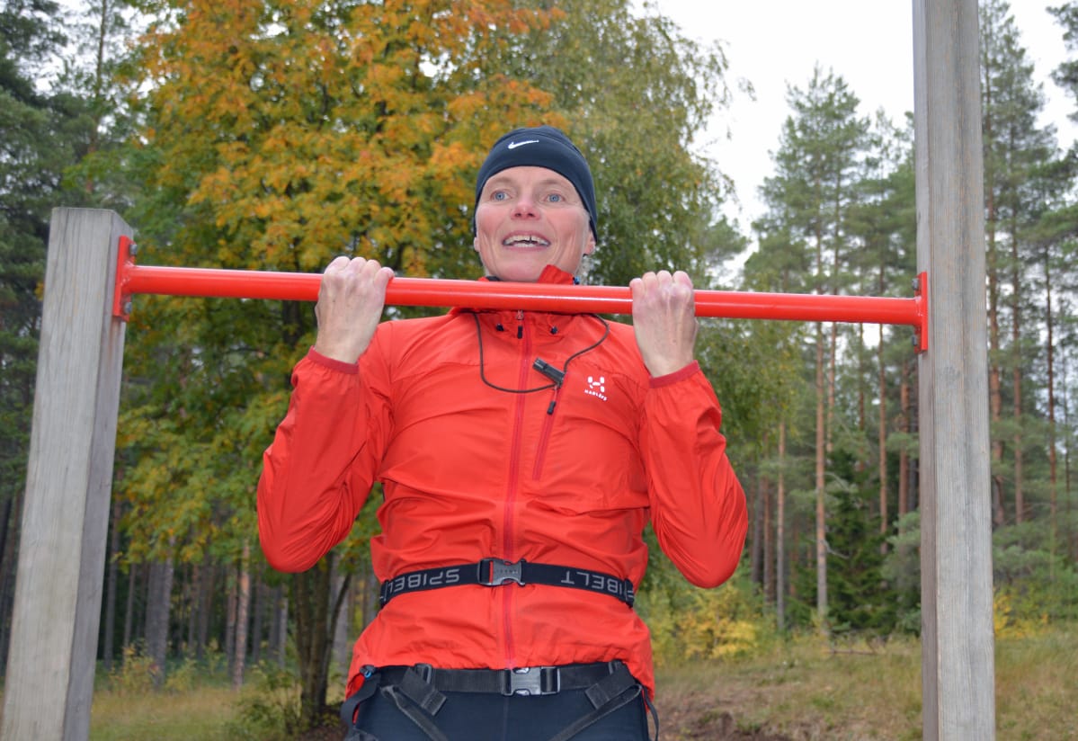 Teija Polso vetää leukoja metsässä olevassa telineessä.