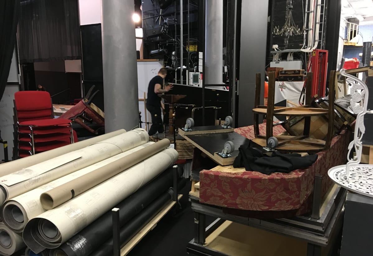 Kouvolan teatterin näyttämön sivu on täynnä tavaraa, kuten lavasteita.