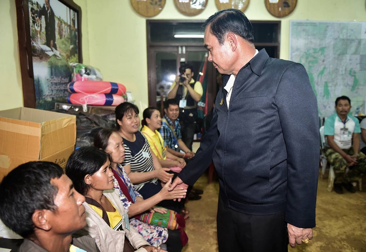 Thaimaan pääministeri Prayut Chan-o-cha tervehtii luolaan jääneiden poikien perheenjäseniä.