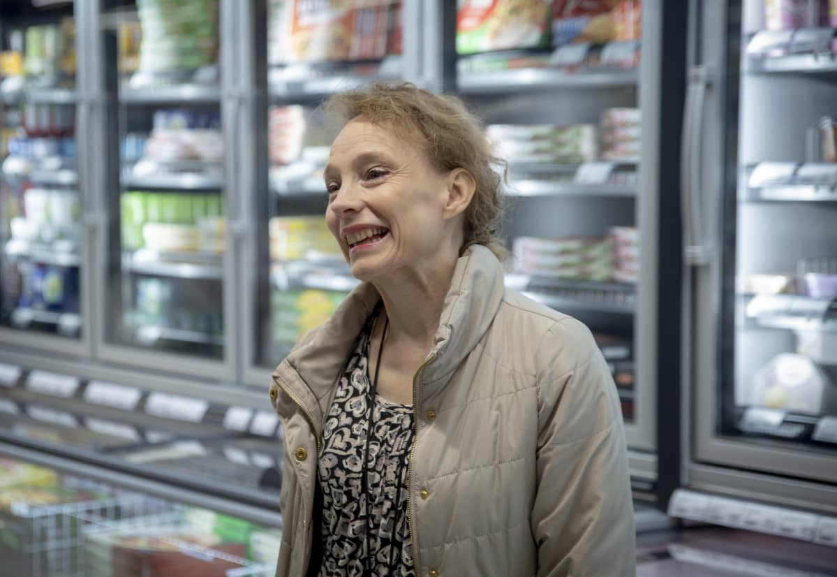 HOK-Elannon vastuullisuuspäällikkö Satu Kattilamäki seisoo S-Marketin pakastekaappien edessä ja nauraa.
